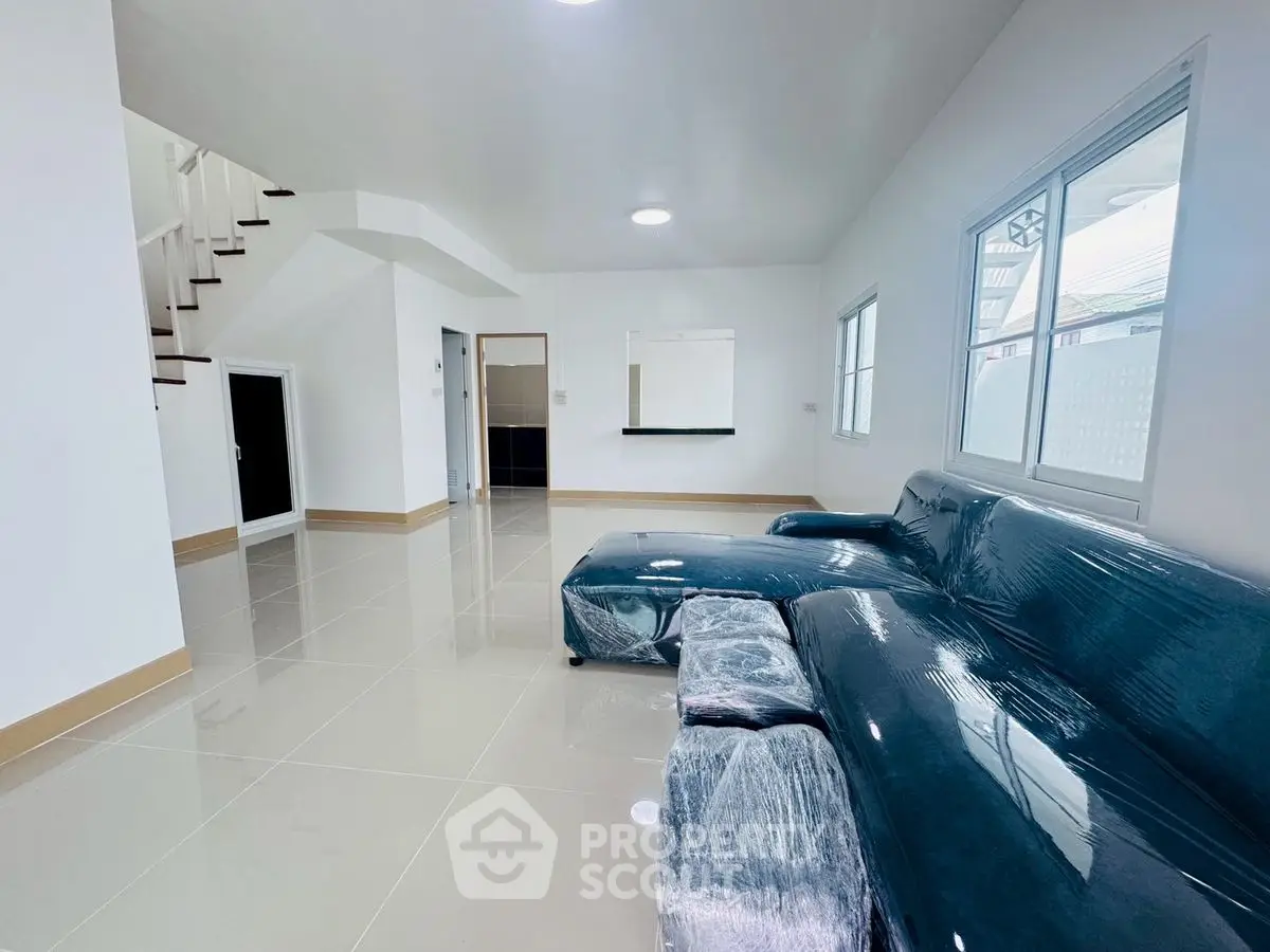 Spacious modern living room with sleek tiled flooring and stylish blue sofa.