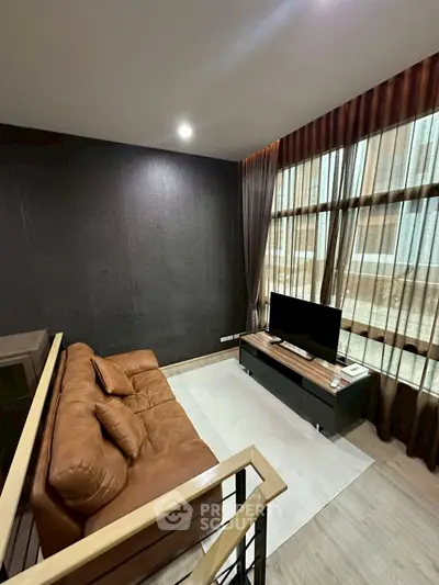 Modern living room with brown leather sofa and large windows in a stylish apartment