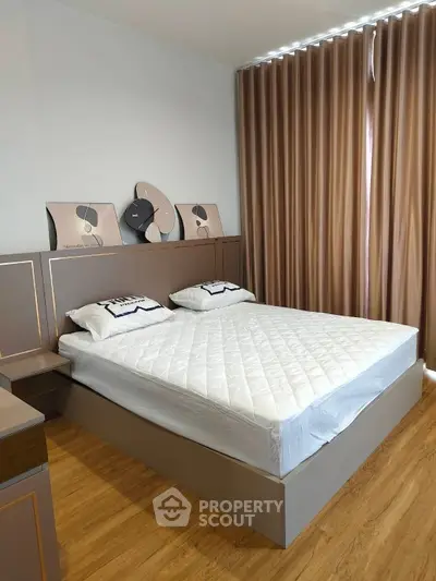 Modern bedroom with stylish decor and large window curtains, featuring a comfortable double bed and wooden flooring.