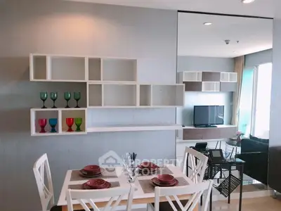 Modern dining and living area with stylish shelving and TV setup
