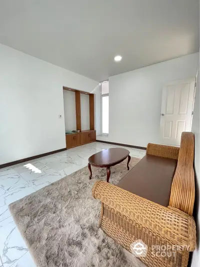 Cozy living room with wicker furniture and plush rug on marble floor