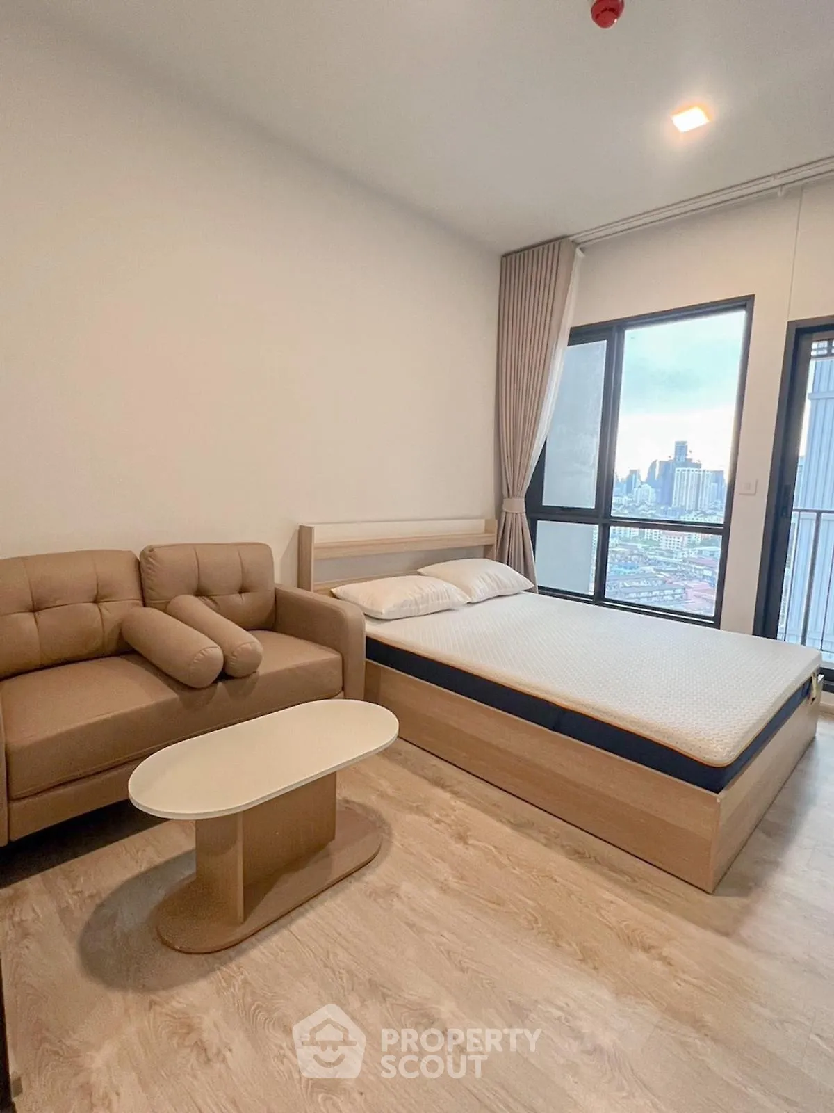 Modern studio apartment with cozy bed and city view