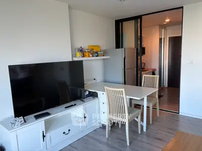 Modern living room with sleek TV and dining area, featuring a stylish open layout and contemporary decor.