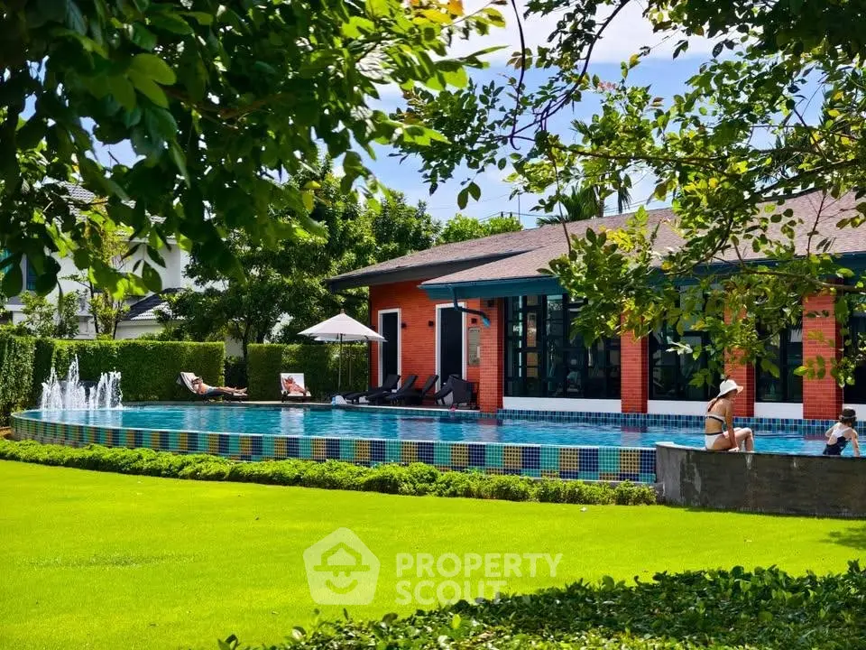 Luxurious residential pool area with lush greenery and modern architecture.