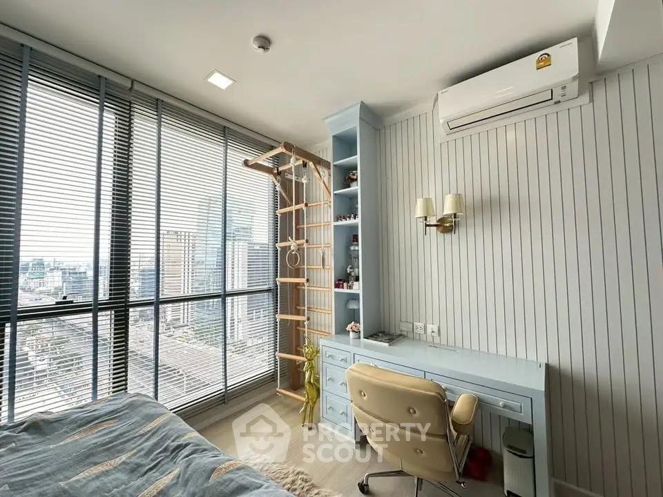 Modern bedroom with city view, featuring a desk, chair, and unique climbing wall for kids.