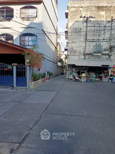 Urban alleyway with residential buildings and small street market
