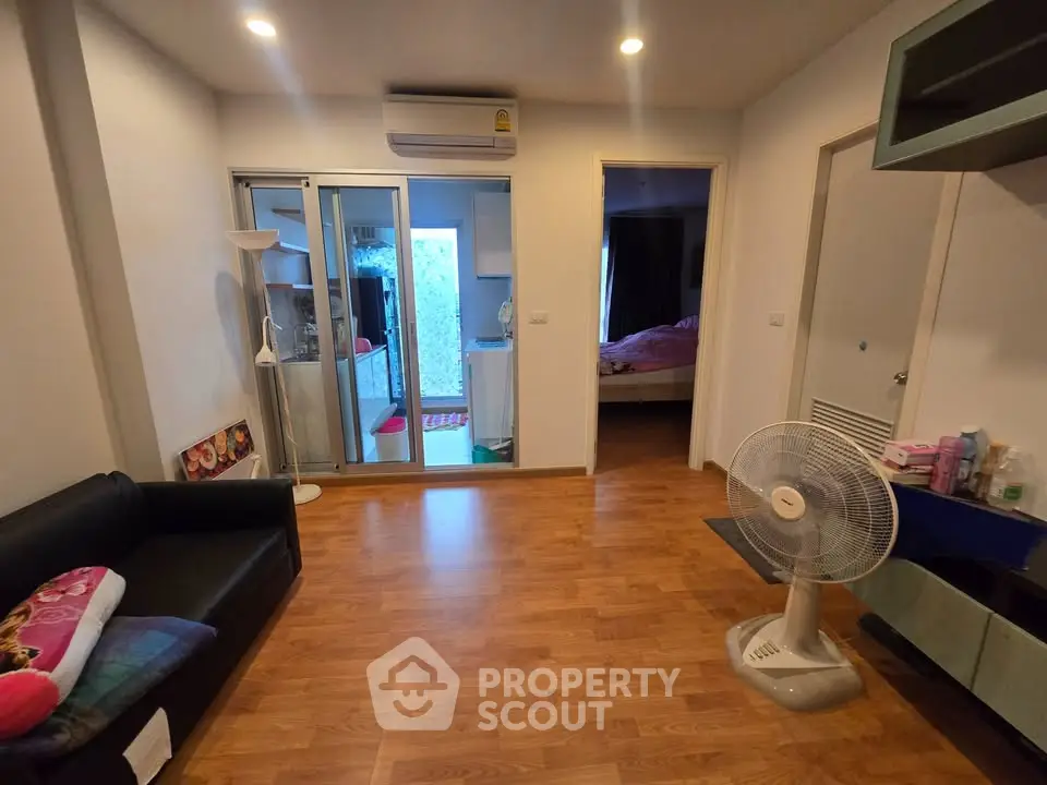 Spacious living room with wooden flooring and modern decor in a cozy apartment.