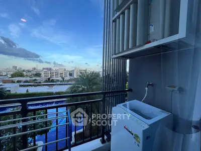 Stunning balcony view with washing machine overlooking cityscape and pool.