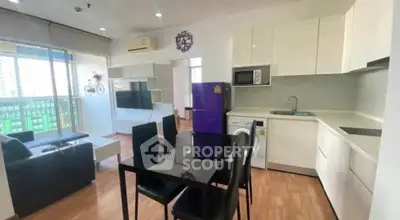 Modern open-layout kitchen and living room with sleek furniture and appliances in a bright apartment.