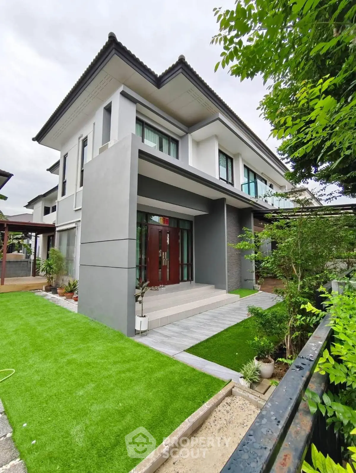 Modern two-story house with lush green lawn and contemporary design