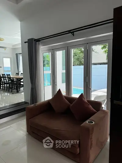 Luxurious living room with pool view and elegant dining area