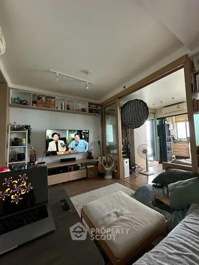 Cozy living room with modern decor and open layout, featuring a TV and stylish furnishings.