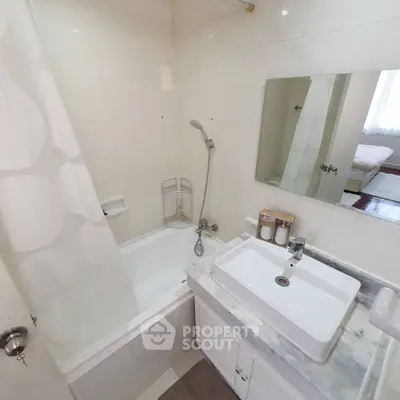 Compact bathroom with bathtub and modern sink in cozy apartment