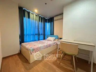 Cozy bedroom with single bed and study desk, featuring wooden flooring and modern decor.