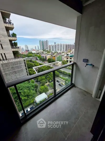 Spacious balcony with stunning cityscape view in modern high-rise apartment.