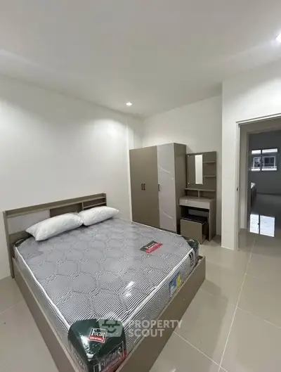 Modern bedroom with sleek furniture and neutral tones, perfect for a cozy and stylish living space.