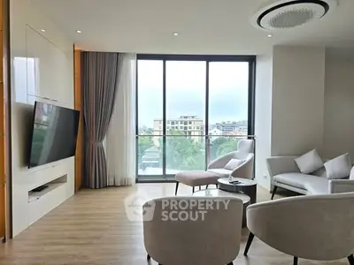 Spacious modern living room with large windows and elegant furnishings, offering a bright and inviting atmosphere.