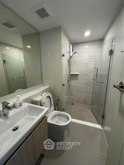 Modern bathroom with glass shower and sleek fixtures in a contemporary apartment.