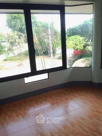 Bright room with large windows and garden view, ideal for a cozy living space.