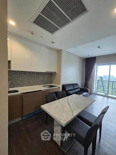 Modern open-layout kitchen with marble dining table and balcony view