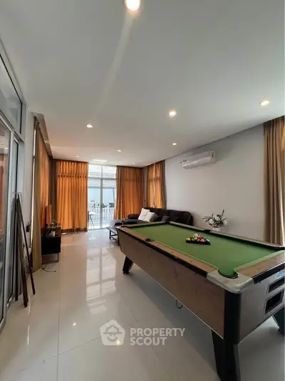 Spacious living room with pool table and modern decor