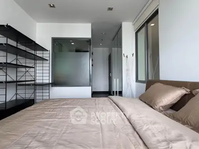 Modern bedroom with sleek shelving and neutral bedding in a stylish apartment.