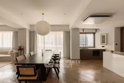 Spacious modern dining area with elegant wooden flooring and large windows.