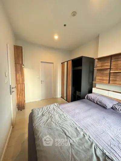 Modern bedroom with stylish wooden furniture and cozy bedding in a contemporary apartment.