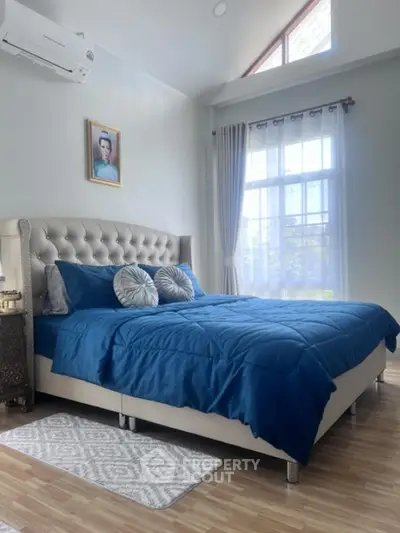 Elegant bedroom with plush bed and natural light, perfect for relaxation.