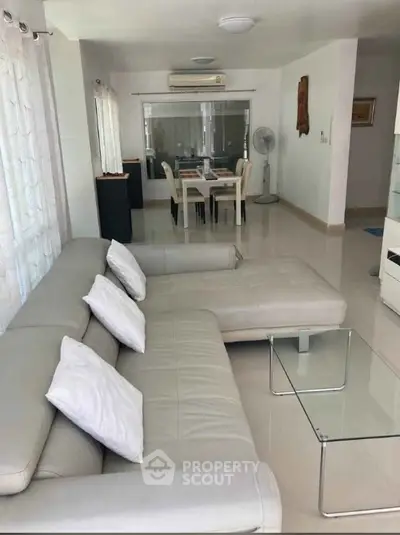 Spacious living room with modern white sofa and glass coffee table