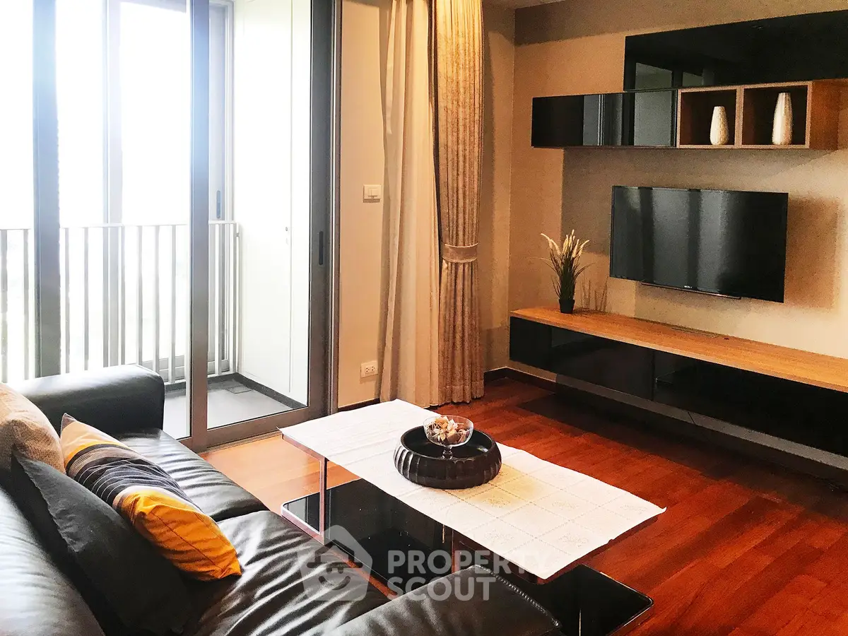 Modern living room with sleek furniture and balcony view, perfect for urban living.