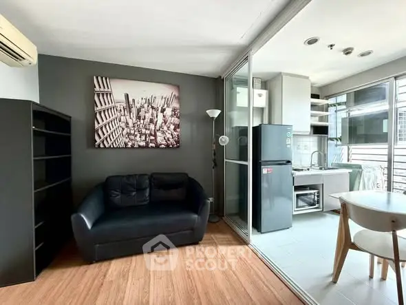 Modern living room with sleek black sofa and open kitchen layout