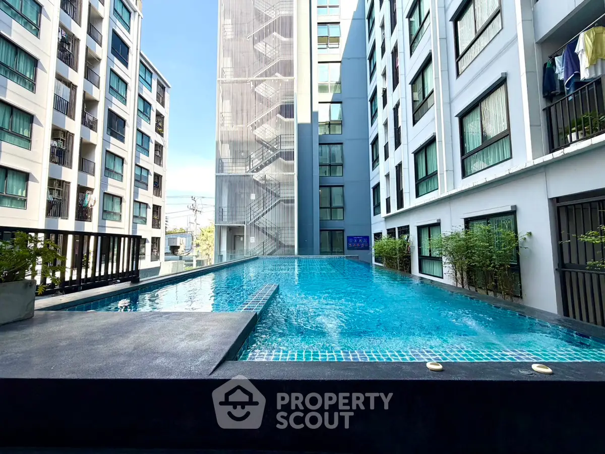 Modern apartment complex with a stunning outdoor pool and contemporary architecture.
