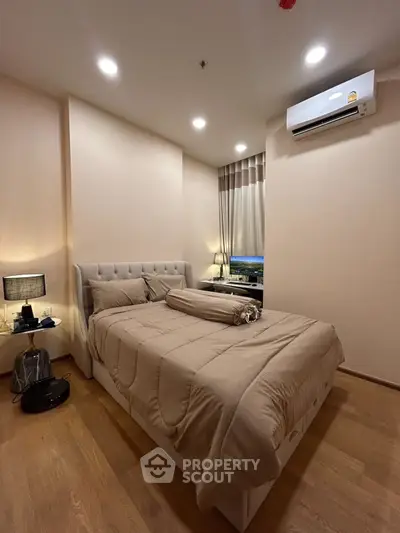 Cozy bedroom with modern decor and ambient lighting, featuring a plush bed and air conditioning.