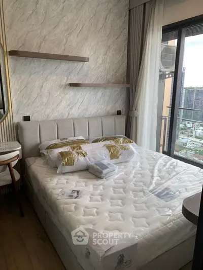 Modern bedroom with stylish decor and city view balcony, perfect for urban living.
