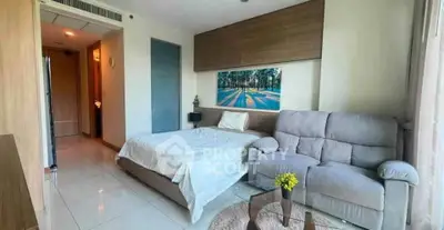 Modern studio apartment with cozy bed and stylish sofa in bright living space.