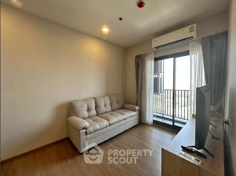 Modern living room with cozy sofa and balcony view in a stylish apartment.