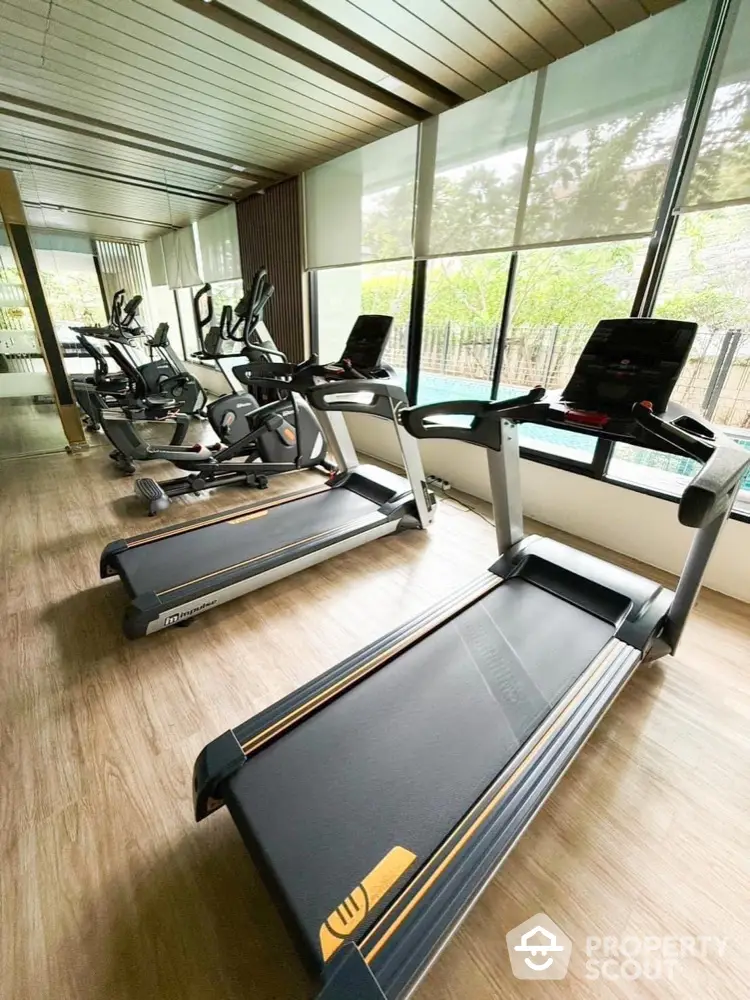 Modern gym with state-of-the-art treadmills and exercise bikes in a bright, spacious room.