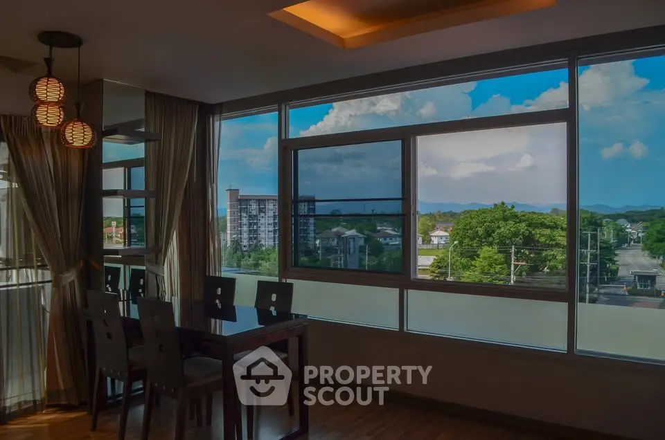 Spacious dining area with large windows offering stunning city and mountain views.
