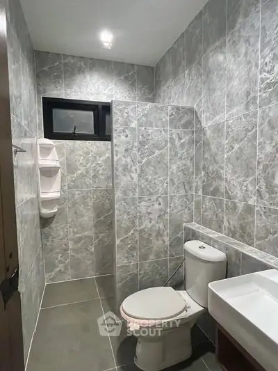 Modern bathroom with sleek gray tiles and contemporary fixtures.