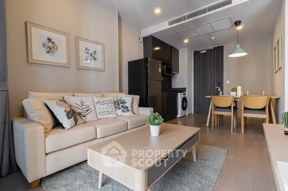 Modern living room with cozy sofa, stylish decor, and compact kitchen in open layout apartment.