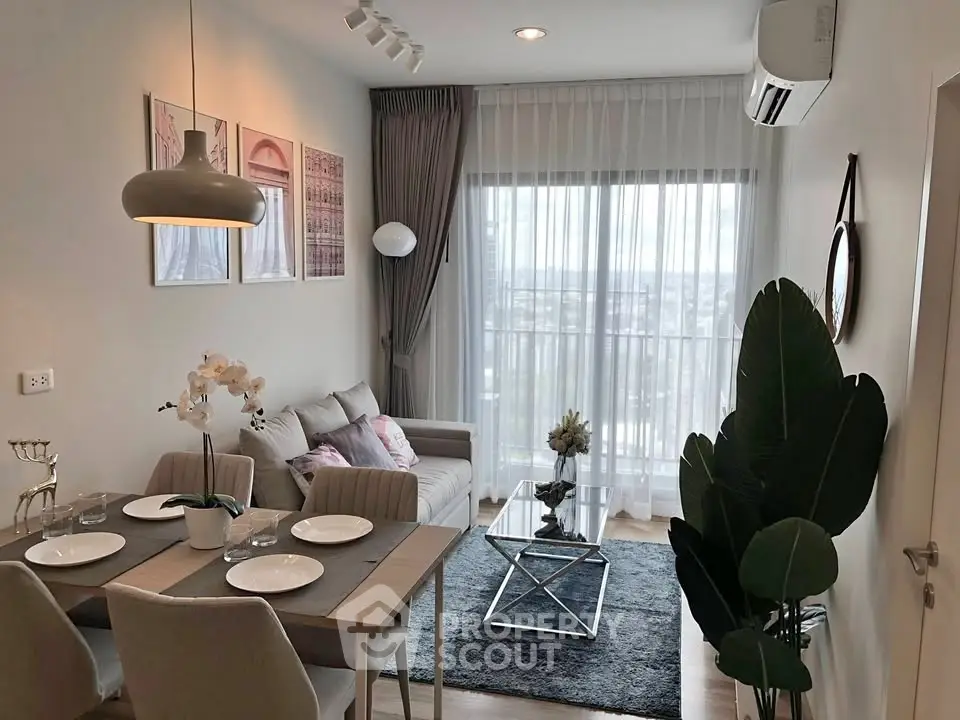 Modern living room with dining area, stylish decor, and large window offering natural light.