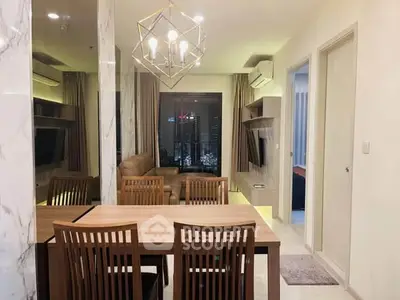 Modern living room with dining area, stylish lighting, and city view from window.
