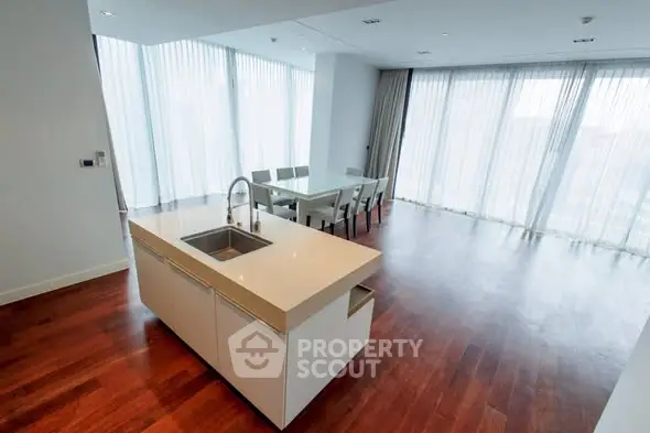 Spacious modern kitchen with open layout and dining area, featuring sleek design and ample natural light.