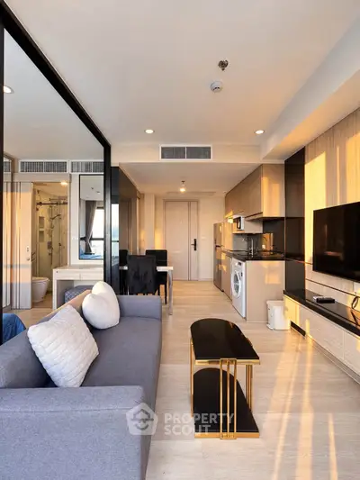 Modern living room with open kitchen, stylish decor, and natural light in a contemporary apartment.