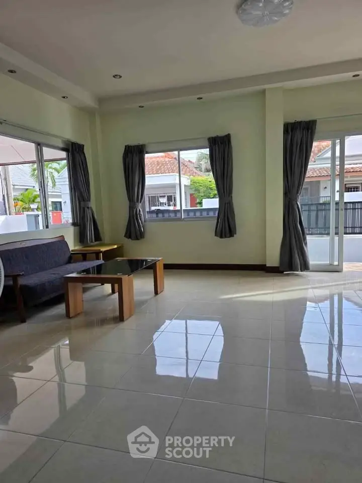 Spacious living room with large windows and modern furniture in a bright home.
