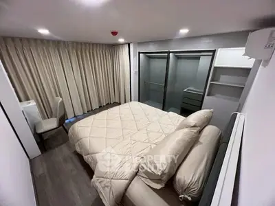 Modern bedroom with cozy bedding and ample closet space in a stylish apartment.