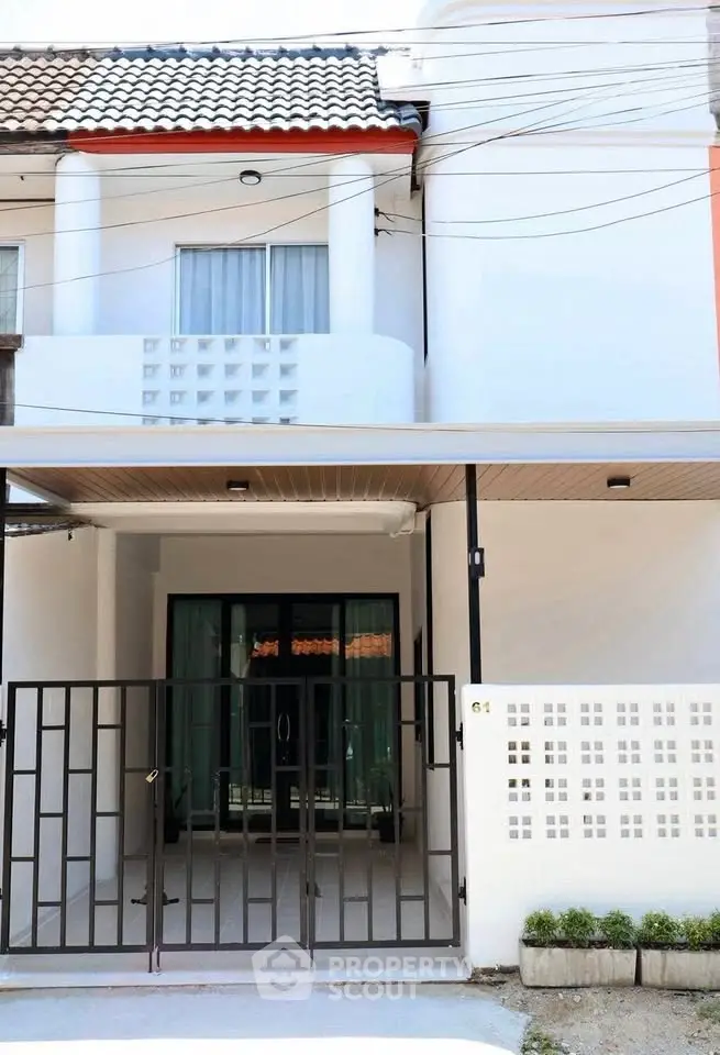 Charming townhouse exterior with modern facade and gated entrance, perfect for urban living.