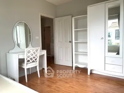 Elegant bedroom with white furniture and wooden flooring, perfect for a cozy and stylish living space.
