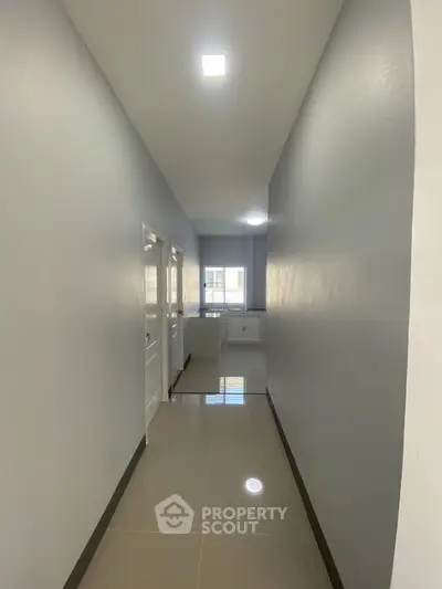 Spacious hallway leading to a bright kitchen with modern cabinets